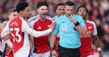 Arsenal players charge referee Oliver